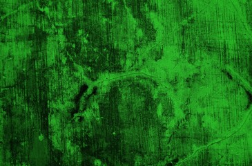 A textured green grunge background with dark patches and rough surface