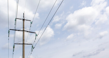 High voltage electrical tower against the sky. High voltage power lines. Electrical distribution station. The passage of the overhead line wire supports carrying light and heat into the house.