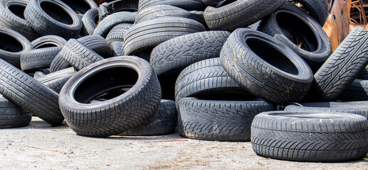 Industrial dump for the processing of used tires and rubber tires. Pile of old tires and wheels for...