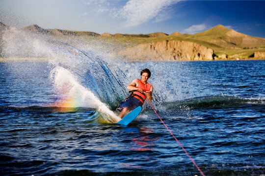 A male waterskiing on a beautiful lake