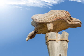 wooden figure of an eagle on a blue sky background