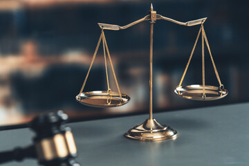 Shiny golden balanced scale and wooden gavel in law firm or lawyer office background as concept...