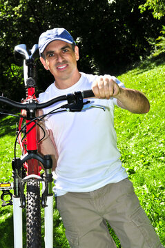 Happy middle aged man with his bicycle in summer part