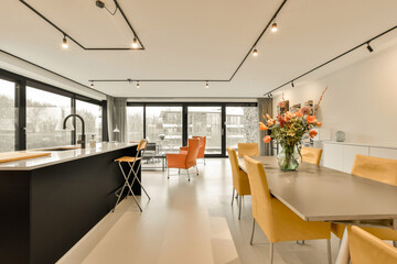 a kitchen and dining area in a modern home with white walls, flooring and black trim on the ceiling