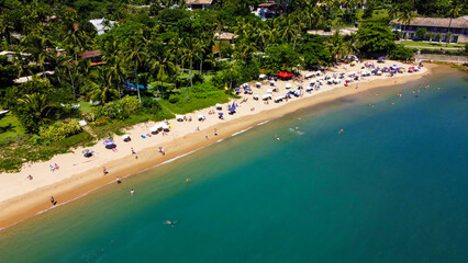 Obraz premium Visão aérea da praia da feiticeira em Ilhabela SP Brasil captada do alto por um drone entre os turistas. 
