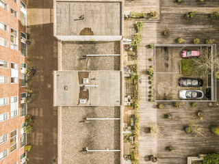 a parking lot with cars parked on the side and buildings in the back ground, taken from an aerial view