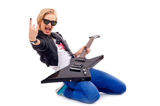 passionate rock girl playing an electric guitar on her knees
