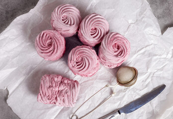 tasty delicious homemade zephyr pink marshmallows with blackberries taste.sweet dessert in box,on kitchen towel,gray tiles surface.whisk tea strainer accessories,sugar powder.pattern close up texture