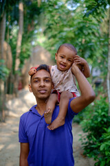 South asian rural young father having fun with his baby boy, adorable family moments, happiness and togetherness concept 