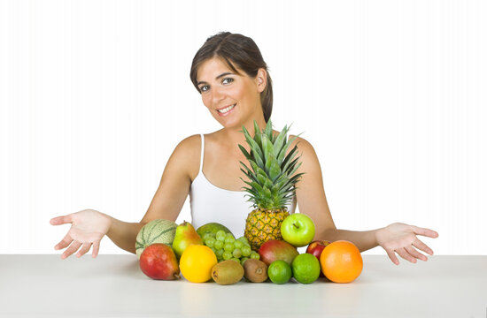 Beautiful young woman with a lot of healhty fruits on her front