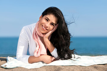 Fototapeta na wymiar Portrait of beautiful smiling native american girl laying at beach
