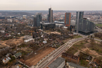 Drone photography of new high rise skyscrapers and old residential houses.
