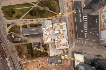 Drone photography of urban construction site of skyscraper complex in the middle of other structures during spring sunny day