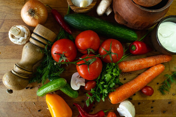 Fresh vegetables and sour cream on a wooden background. Top view.