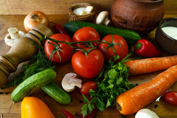 Fresh vegetables on a wooden background. Tomatoes, mushrooms, cucumbers, onions, parsley and sour cream