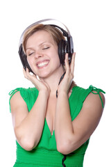 beautiful girl in a green dress listening to music with big headphones, isolated on white