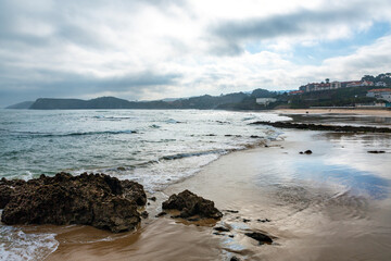 beach at sunrise in the spanish town of comillas, cantabria.
