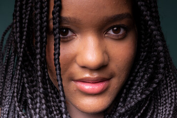 Close-up portrait of beautiful young black woman with braided hair.