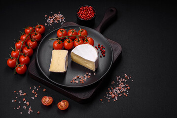 Delicious fresh brie cheese in the form of a mini head with cherry tomatoes