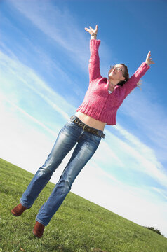 Young woman in casual dress leaps in the air with joy!