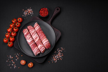 Raw minced meat wrapped in bacon with salt and spices or cevapcici