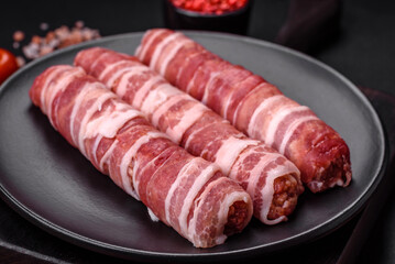 Raw minced meat wrapped in bacon with salt and spices or cevapcici