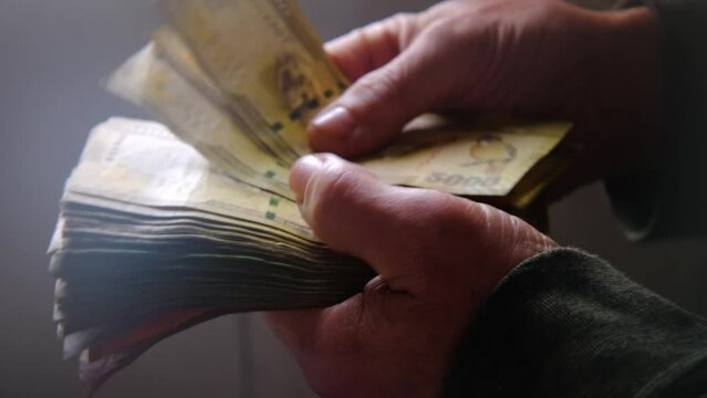 man holding, counts lot of national currency of Sri Lanka, paper money bills Rupee banknotes, devaluation, high inflation of state, exchange rate on travel, vacation, savings, banking, tax payment