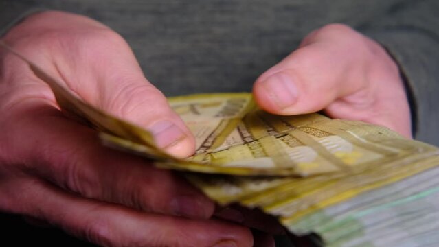 man holding, counts lot of national currency of Sri Lanka, paper money bills Rupee banknotes, devaluation, high inflation of state, exchange rate on travel, vacation, savings, banking, tax payment