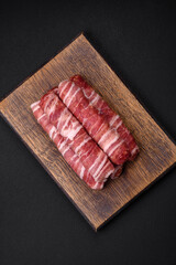 Raw minced meat wrapped in bacon with salt and spices or cevapcici