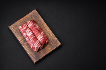 Raw minced meat wrapped in bacon with salt and spices or cevapcici