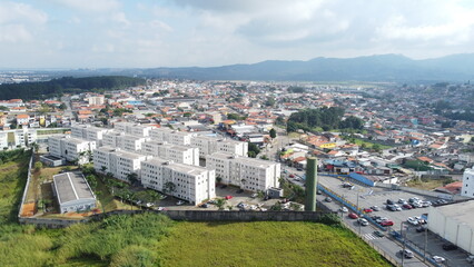 Visão aérea de um condomínio de prédios residenciais, destacando a arquitetura moderna e a organização da área urbana com diversos apartamentos e espaços comuns na cidade