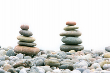 Fototapeta na wymiar two stacks of stones over white, focus on the left one
