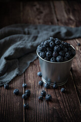 Fototapeta na wymiar Bucket with fresh blueberries on dark background 
