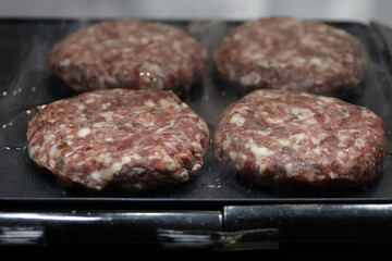 hamburguesas friéndose  ala plancha
