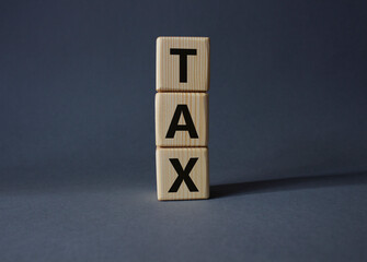 Tax symbol. Wooden cubes with word Tax. Beautiful grey background. Business and Finace and Tax concept. Copy space.