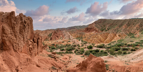 Scenery from Fairytale Canyon, unique rock formation located in Kyrgyzstan. Canyon is known for its unusual and colorful rock formations, which have been shaped over time by wind and water erosion.