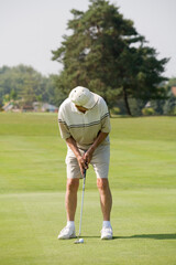 Obraz premium Elderly Man Playing Golf at the Golf Course