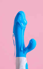 Vibrator with lubricant on pink background