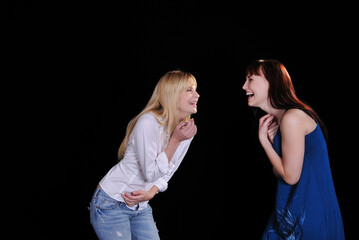 2 ladies having fun and laughing on a black background