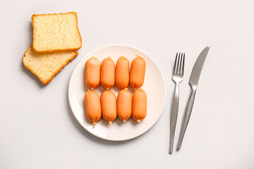 Plate of tasty boiled sausages on grey background