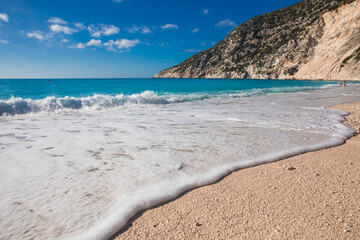  Myrtos beach with white sand and azure water against blue sky - Kefalonia island, Ionian sea, Greece.