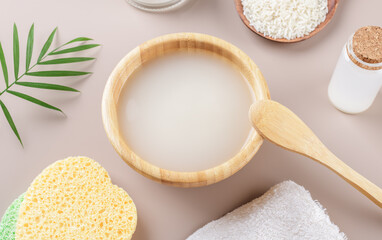 Homemade cosmetic rice water with ingredients on beige background, healthy beauty treatment ingredients for homemade comsetics, beauty recipe for home spa, natural skincare preparation, close up