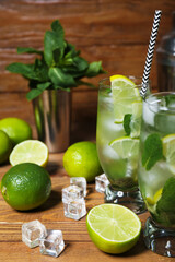 Glasses of cold mojito on wooden background