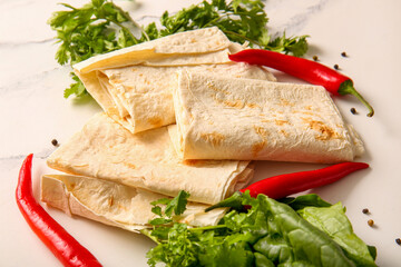 Fresh lavash, greens and chili pepper on white marble background