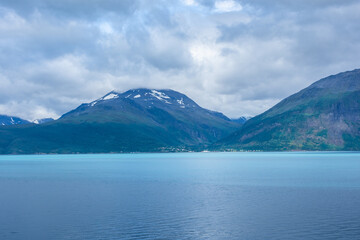 Beautiful  view over a Norwegian fjord from the sea with turquoise water between the mountains