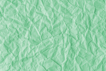 Recycled crumpled light green paper texture background. Wrinkled and creased abstract backdrop,...