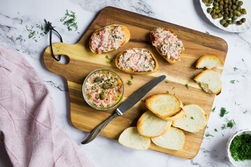 Salmon rillettes, mousse, pate and toasts on wooden background