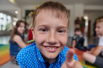 Portrait photo of a smiling boy in a preschool institution having fun