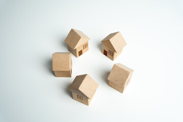 Wooden toy houses stand in a circle. Community of homeowners. Build, buy or sell real estate. Construction project. Buildings. Housing and urbanization. Real estate market. Eco friendly.