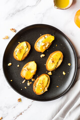 Baguette slices with cream cheese, persimmon, honey, and nuts